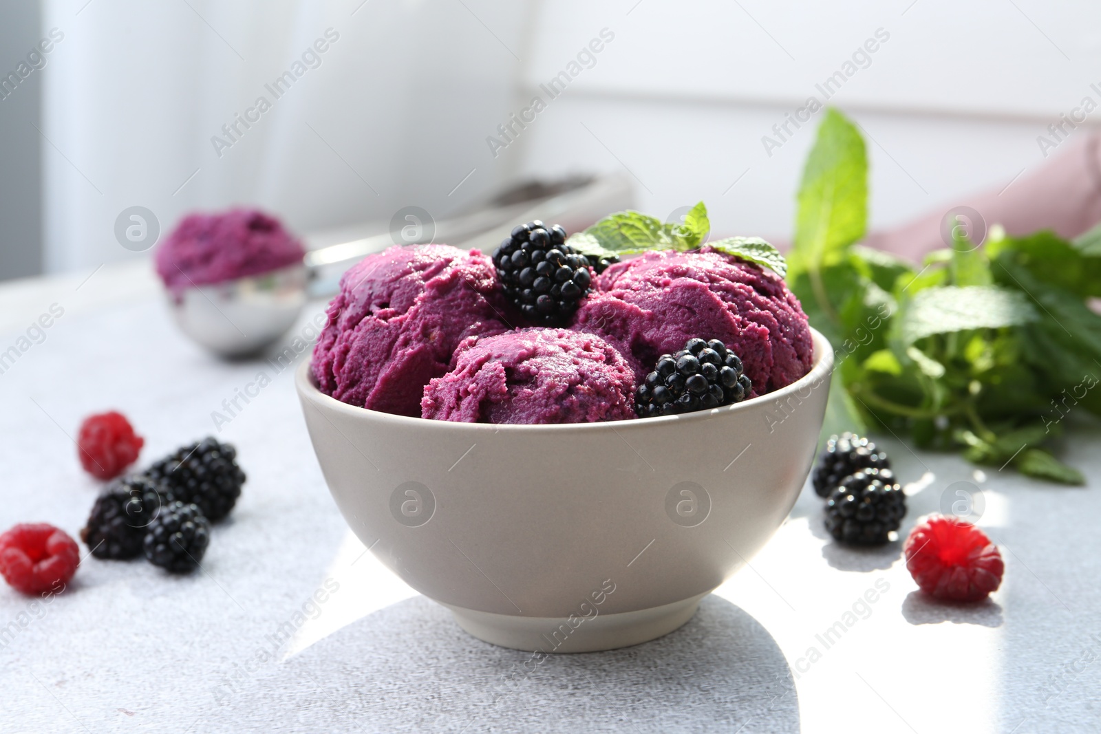 Photo of Delicious blackberry sorbet, mint and fresh berries on grey table