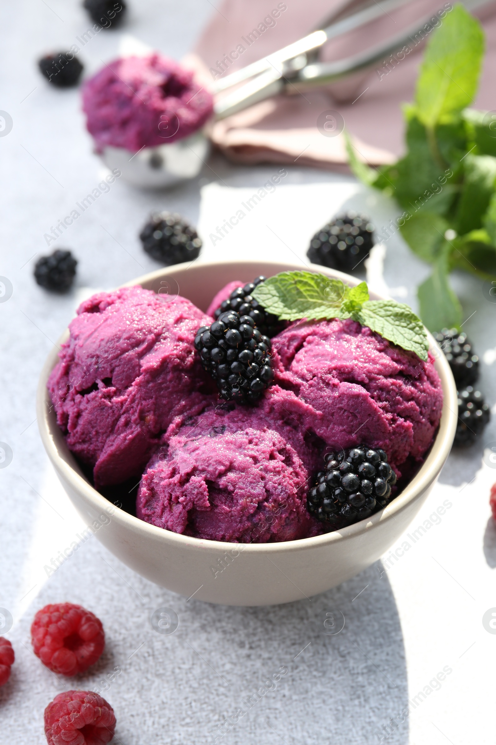 Photo of Delicious blackberry sorbet, mint and fresh berries on grey table