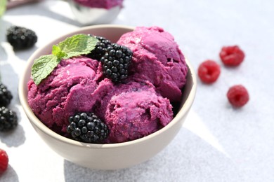 Photo of Delicious blackberry sorbet, mint and fresh berries on grey table, closeup. Space for text