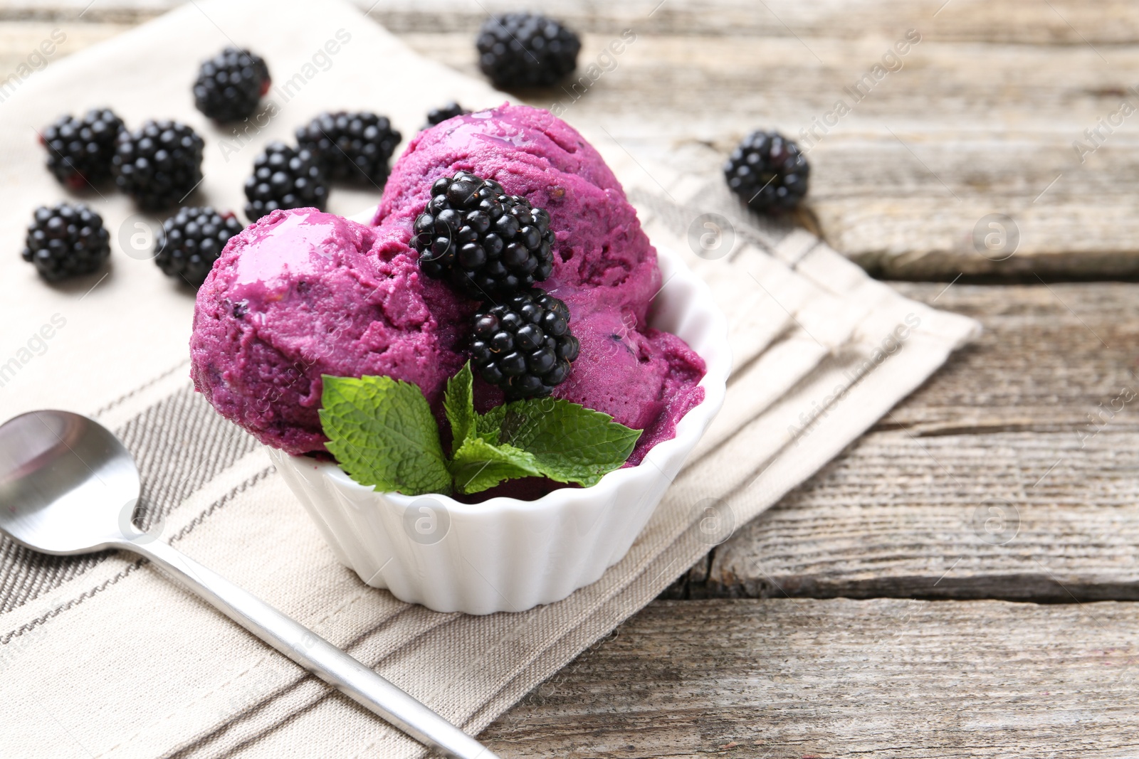 Photo of Delicious blackberry sorbet, mint and fresh berries on wooden table, closeup. Space for text