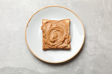 Photo of Tasty sandwich with peanut butter and nuts on grey textured table, top view