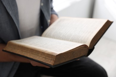 Photo of Man with Bible indoors, closeup. Christian faith