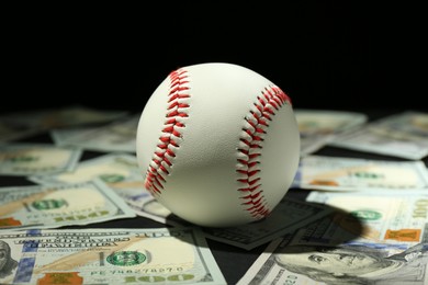 Photo of Baseball ball and dollar banknotes on table, closeup