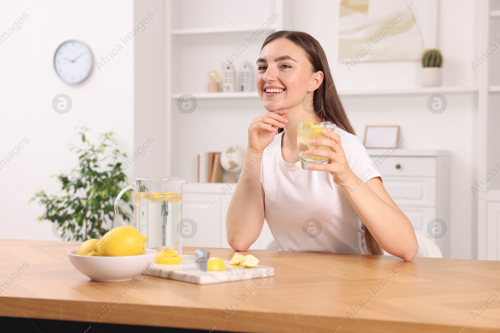 Photo of Woman with glass of lemon water indoors