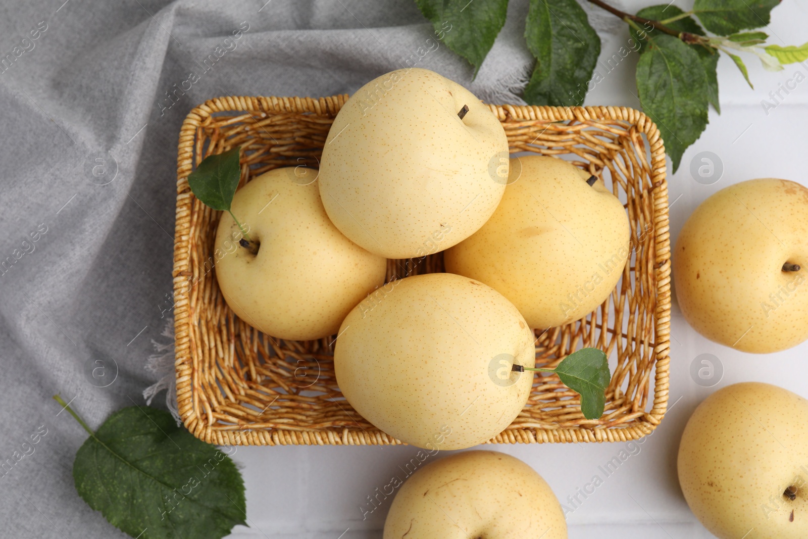 Photo of Delicious fresh apple pears and green leaves on white table, top view