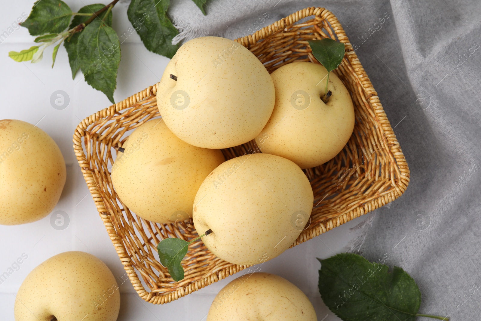 Photo of Delicious fresh apple pears and green leaves on white table, top view