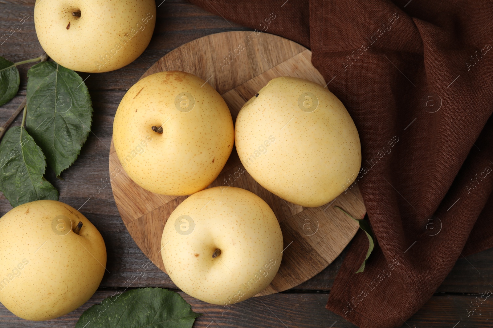 Photo of Delicious fresh apple pears and green leaves on wooden table, top view