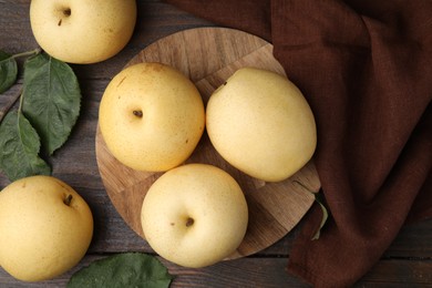 Delicious fresh apple pears and green leaves on wooden table, top view