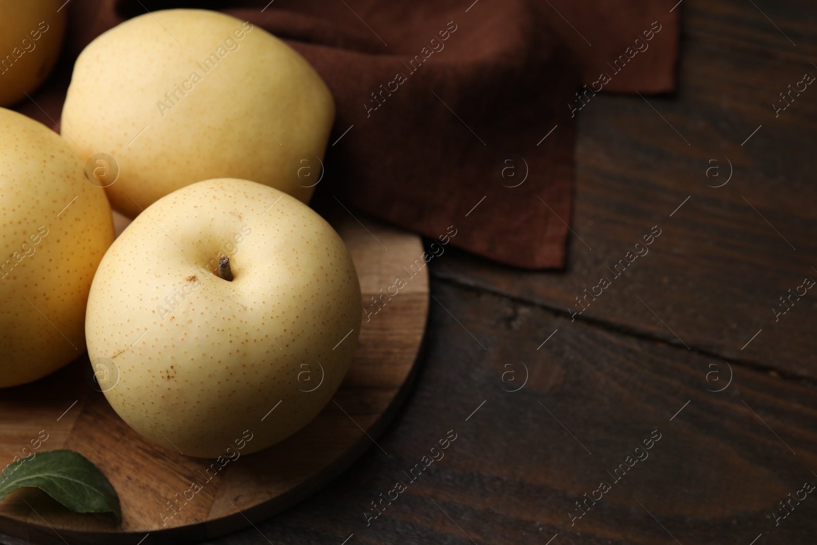 Photo of Delicious fresh apple pears on wooden table, closeup. Space for text