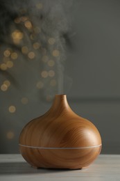 Aroma oil diffuser on white wooden table