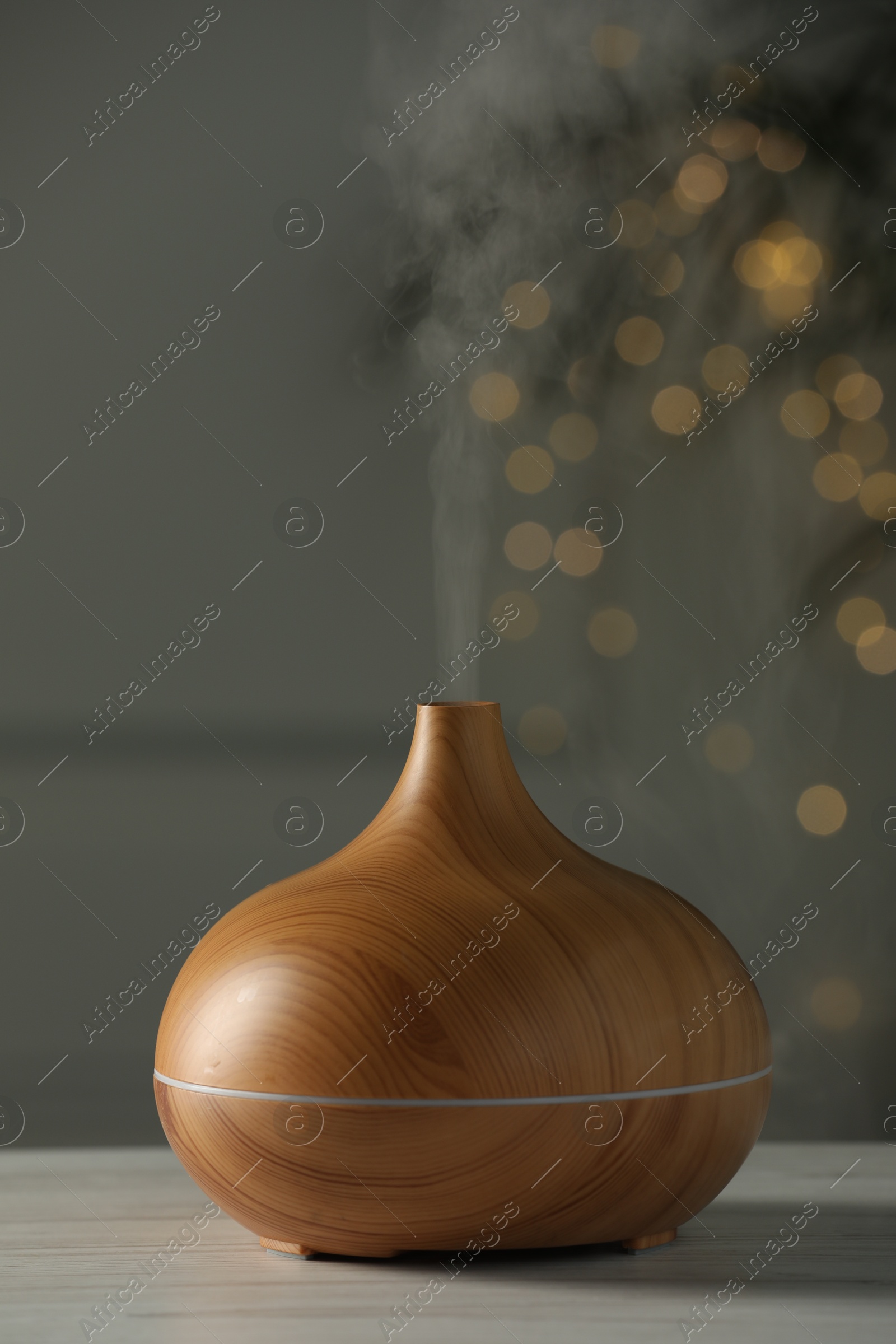 Photo of Aroma oil diffuser on white wooden table