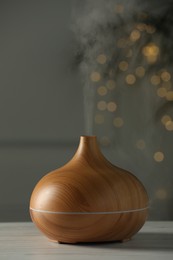 Aroma oil diffuser on white wooden table