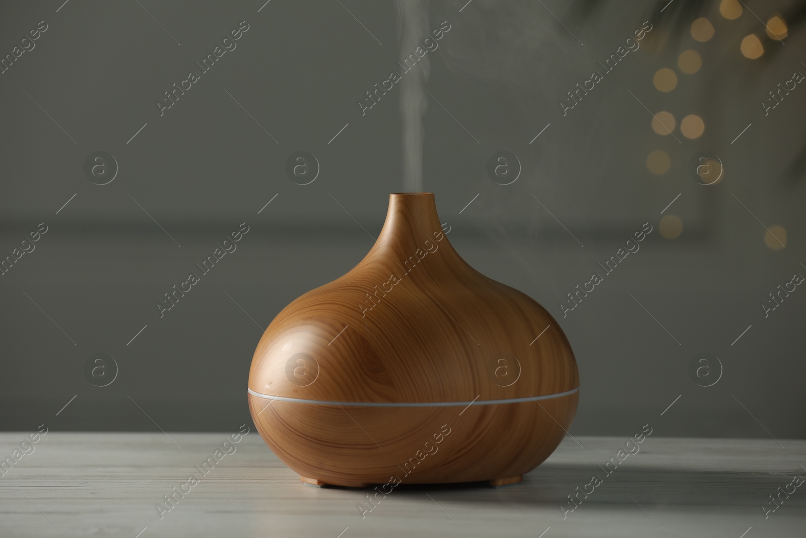 Photo of Aroma oil diffuser on white wooden table