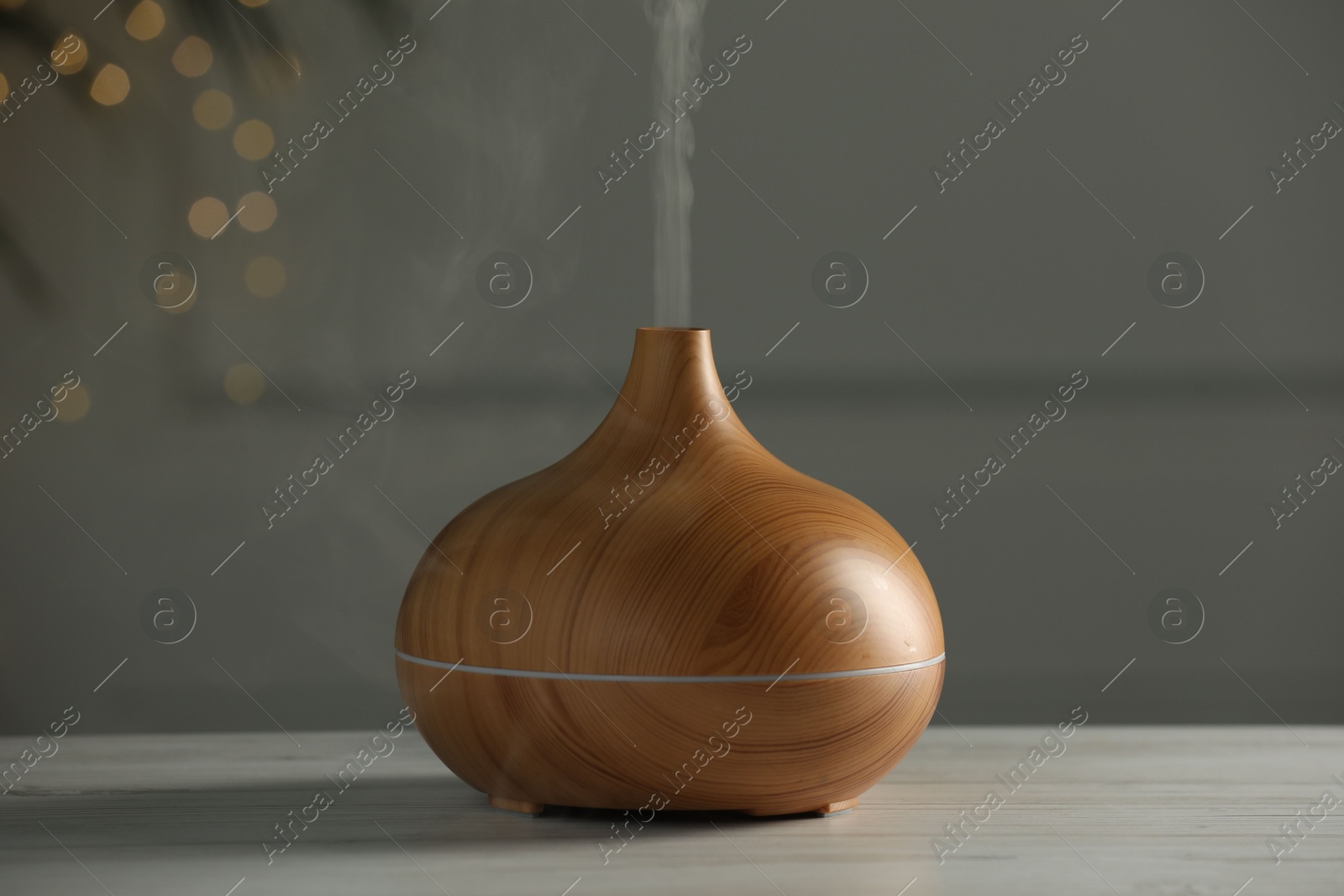 Photo of Aroma oil diffuser on white wooden table