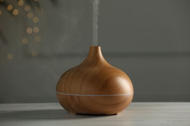 Aroma oil diffuser on white wooden table