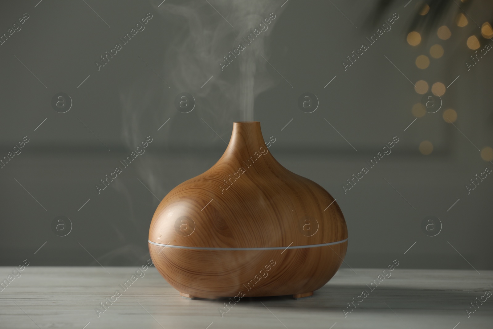 Photo of Aroma oil diffuser on white wooden table