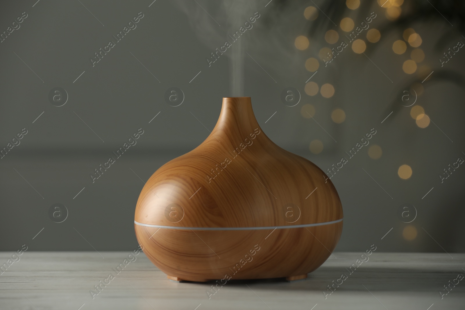 Photo of Aroma oil diffuser on white wooden table