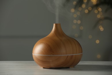 Photo of Aroma oil diffuser on white wooden table