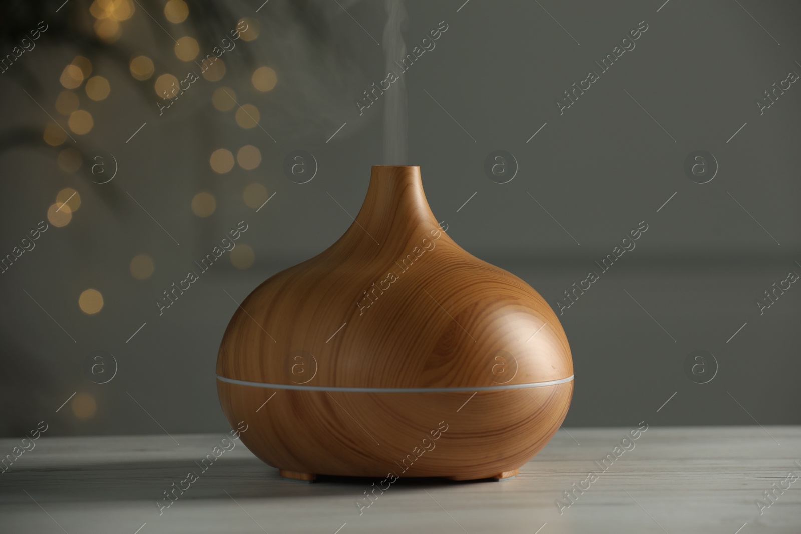 Photo of Aroma oil diffuser on white wooden table