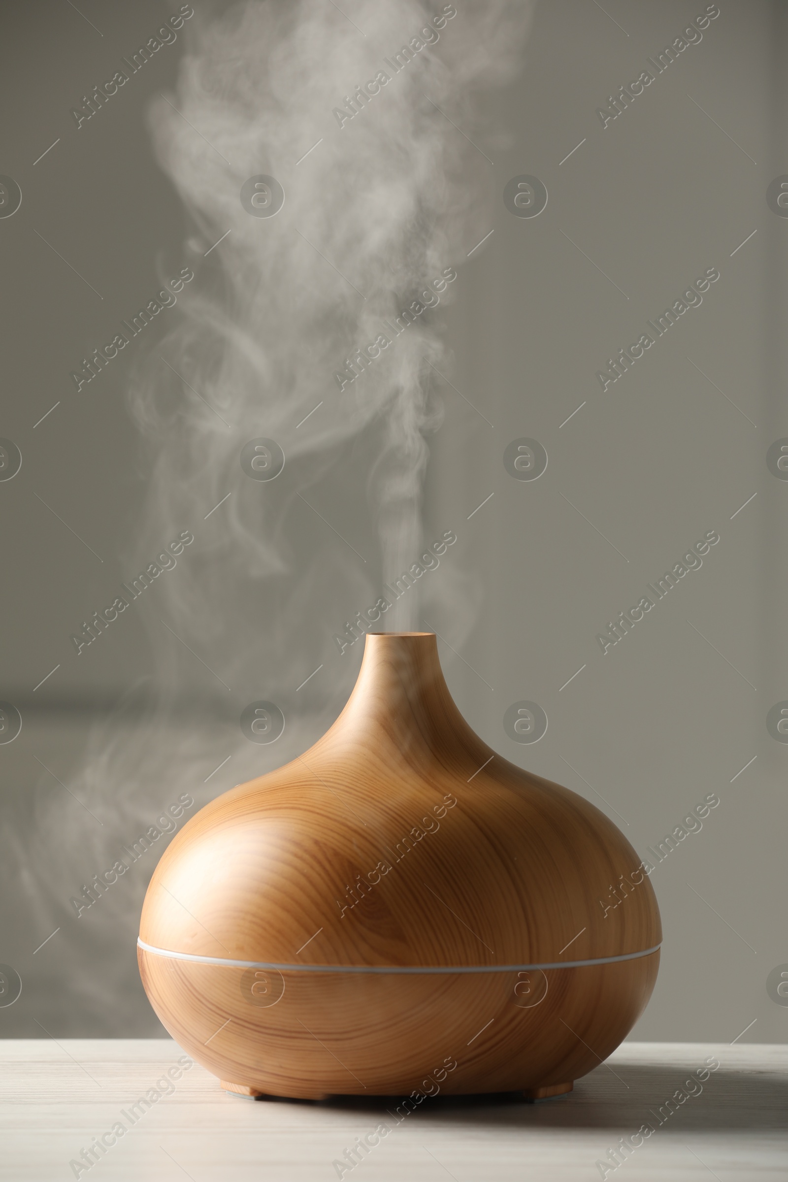 Photo of Aroma oil diffuser on white wooden table