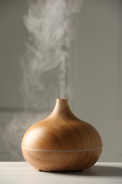 Aroma oil diffuser on white wooden table