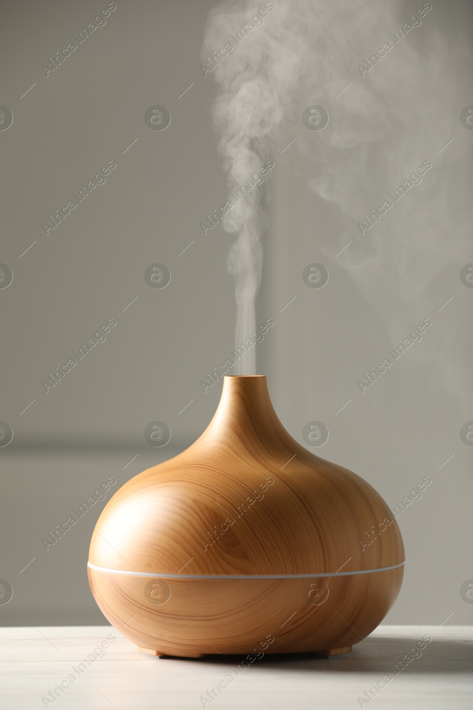 Photo of Aroma oil diffuser on white wooden table