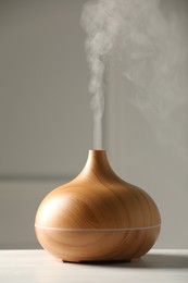 Aroma oil diffuser on white wooden table