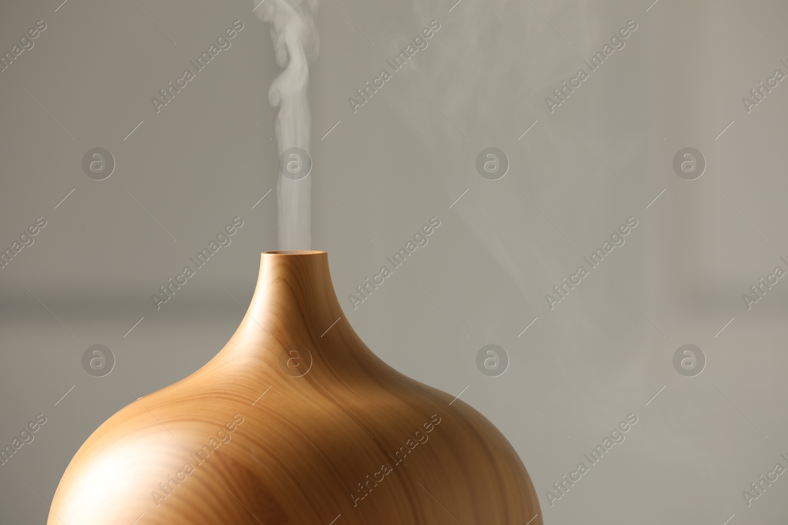 Photo of Aroma oil diffuser on grey background, closeup. Space for text