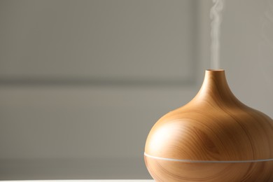 Aroma oil diffuser on grey background, closeup. Space for text