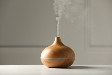 Aroma oil diffuser on white wooden table