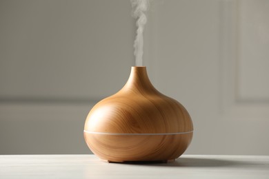 Aroma oil diffuser on white wooden table