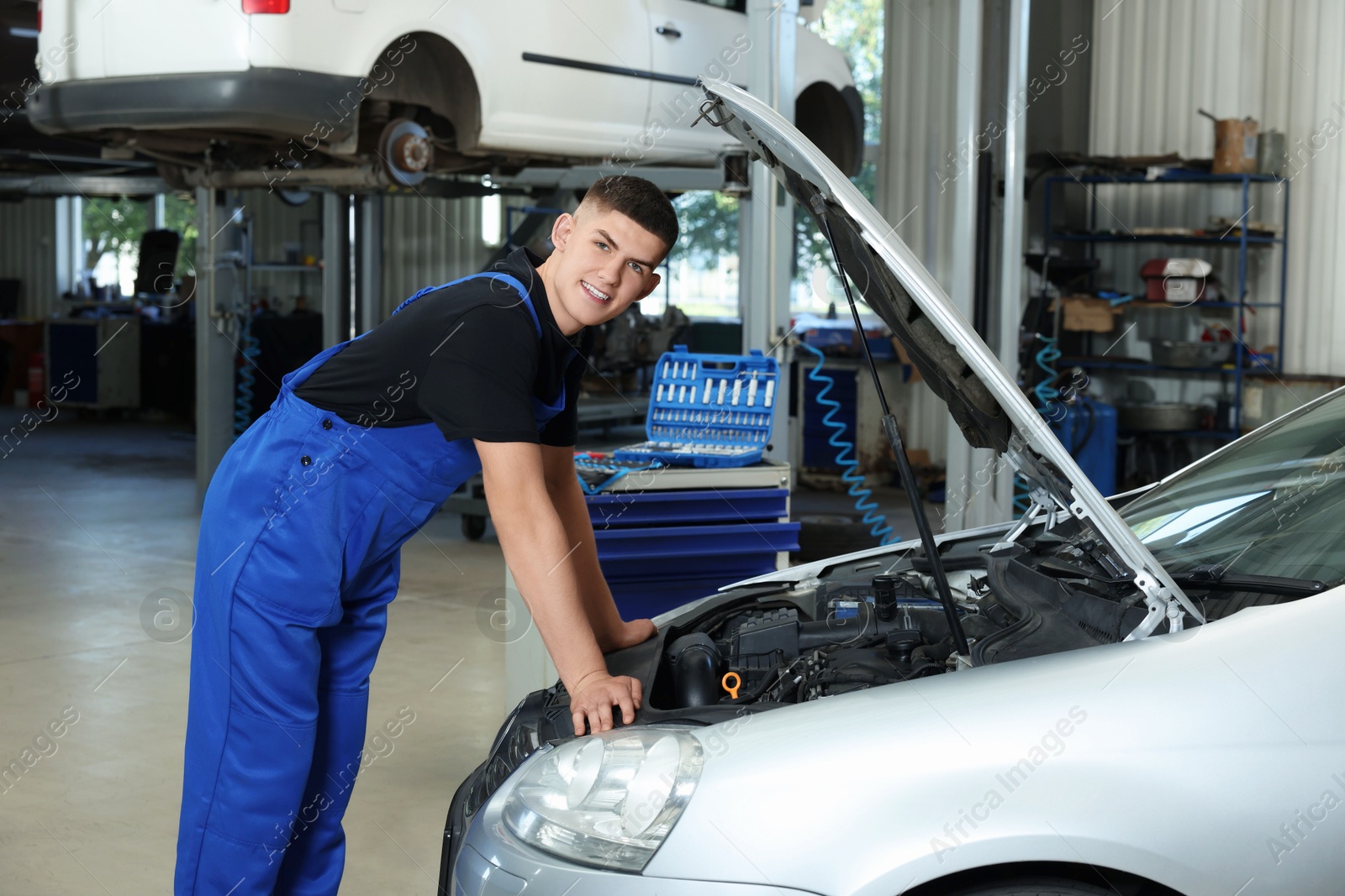 Photo of Young auto mechanic fixing car at automobile repair shop