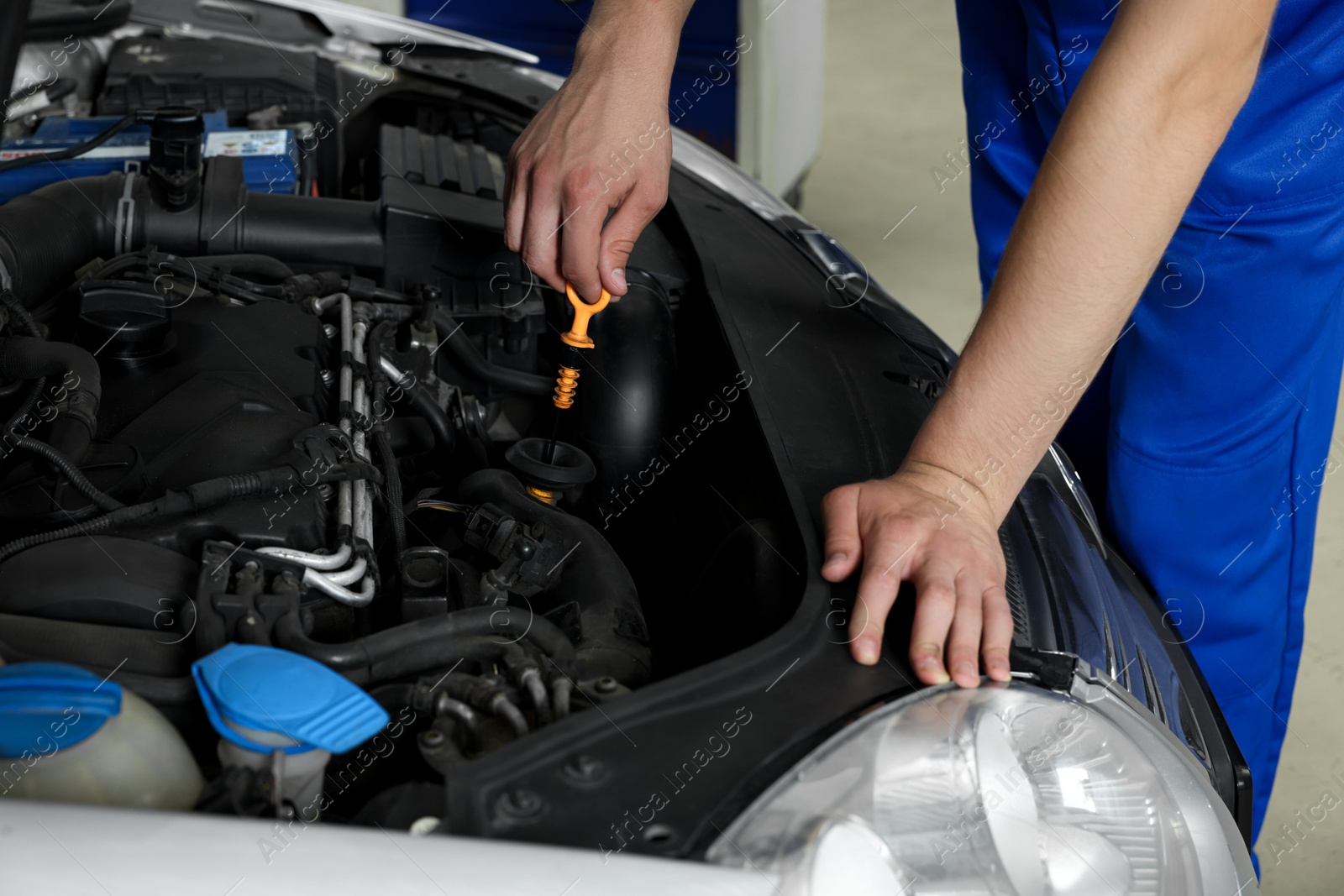 Photo of Auto mechanic fixing car at automobile repair shop, closeup