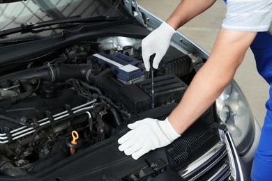 Photo of Auto mechanic fixing car at automobile repair shop, closeup