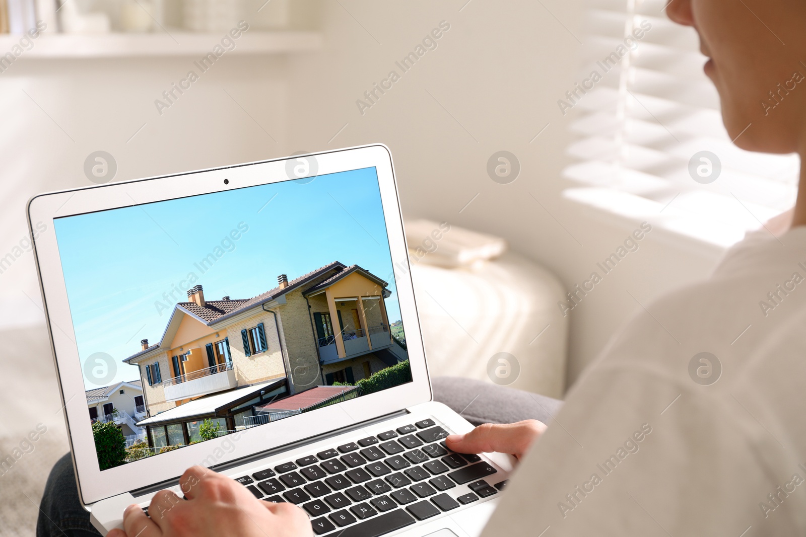 Image of Man looking for house on real estate market website at home, closeup