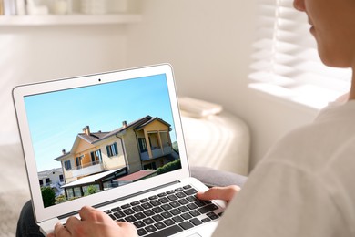 Man looking for house on real estate market website at home, closeup