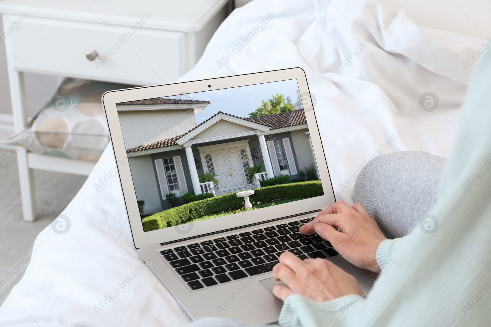 Image of Woman looking for house on real estate market website at home, closeup