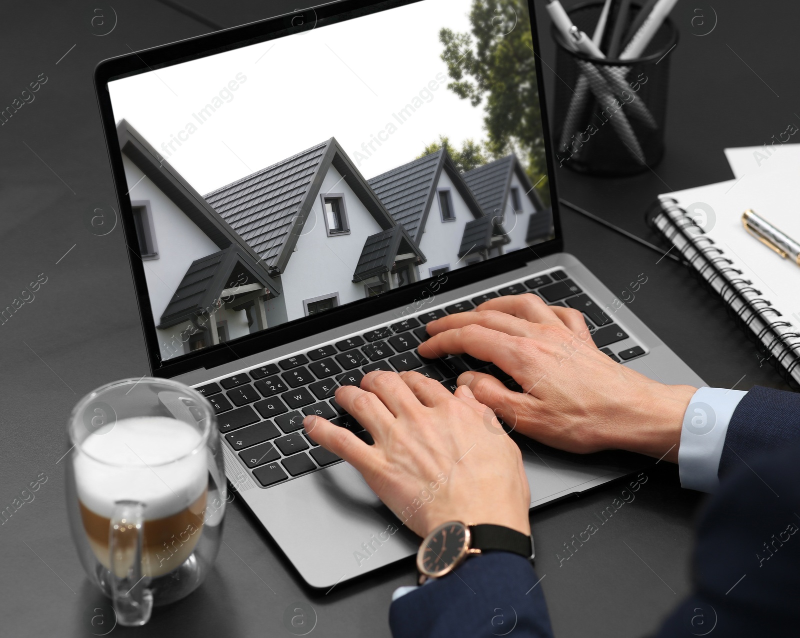 Image of Woman looking for house on real estate market website at table, closeup