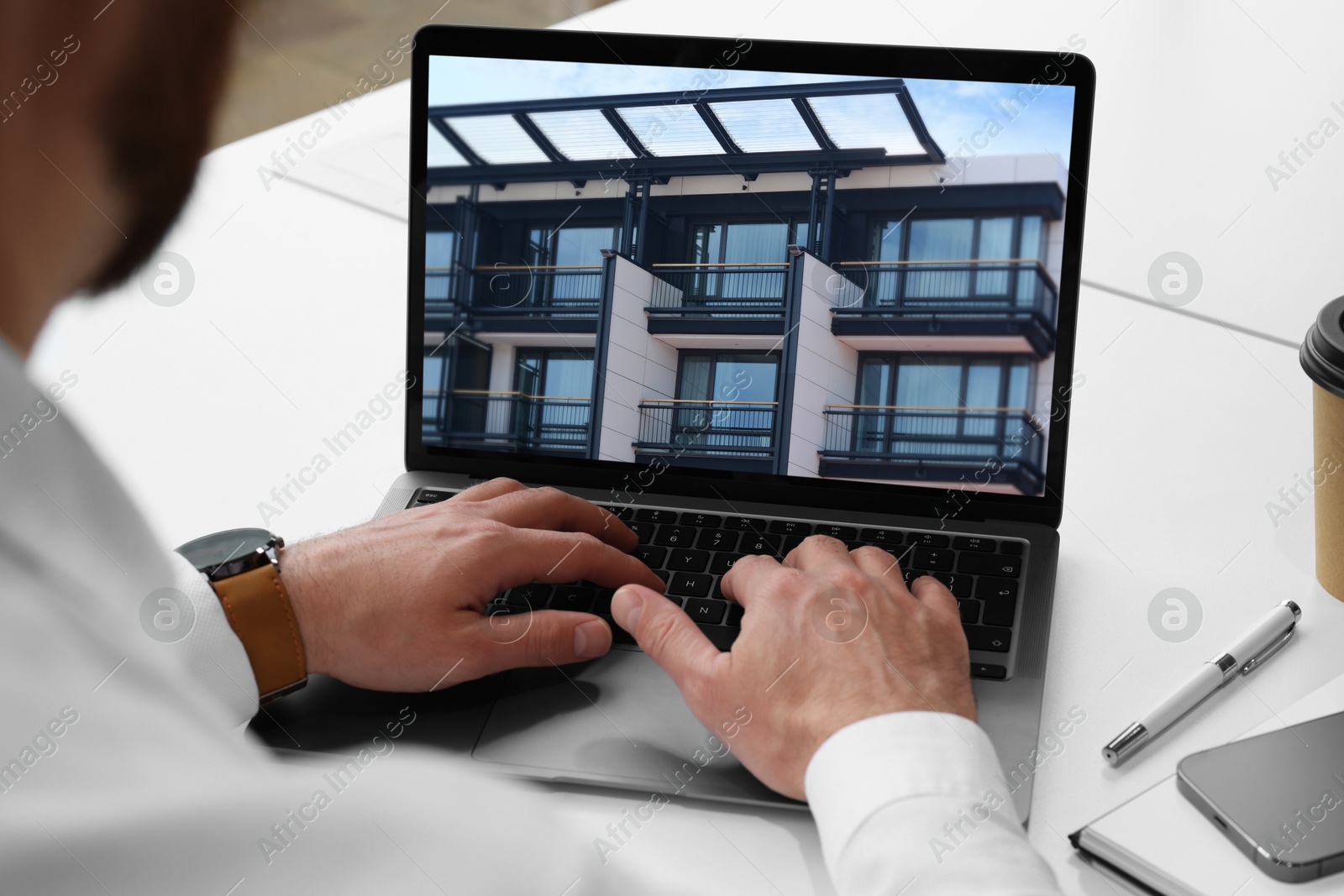 Image of Man looking for house on real estate market website at table, closeup