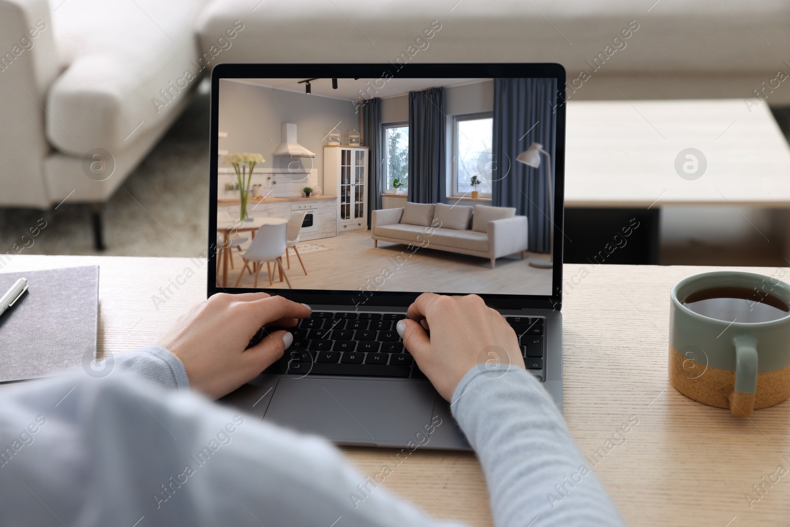 Image of Woman looking for house on real estate market website at table, closeup