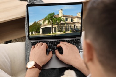 Image of Man looking for house on real estate market website at home, closeup