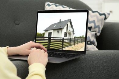 Woman looking for house on real estate market website at home, closeup