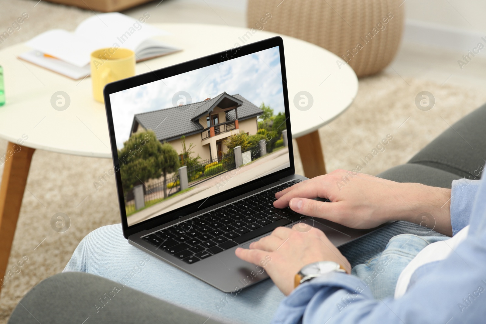 Image of Man looking for house on real estate market website at home, closeup