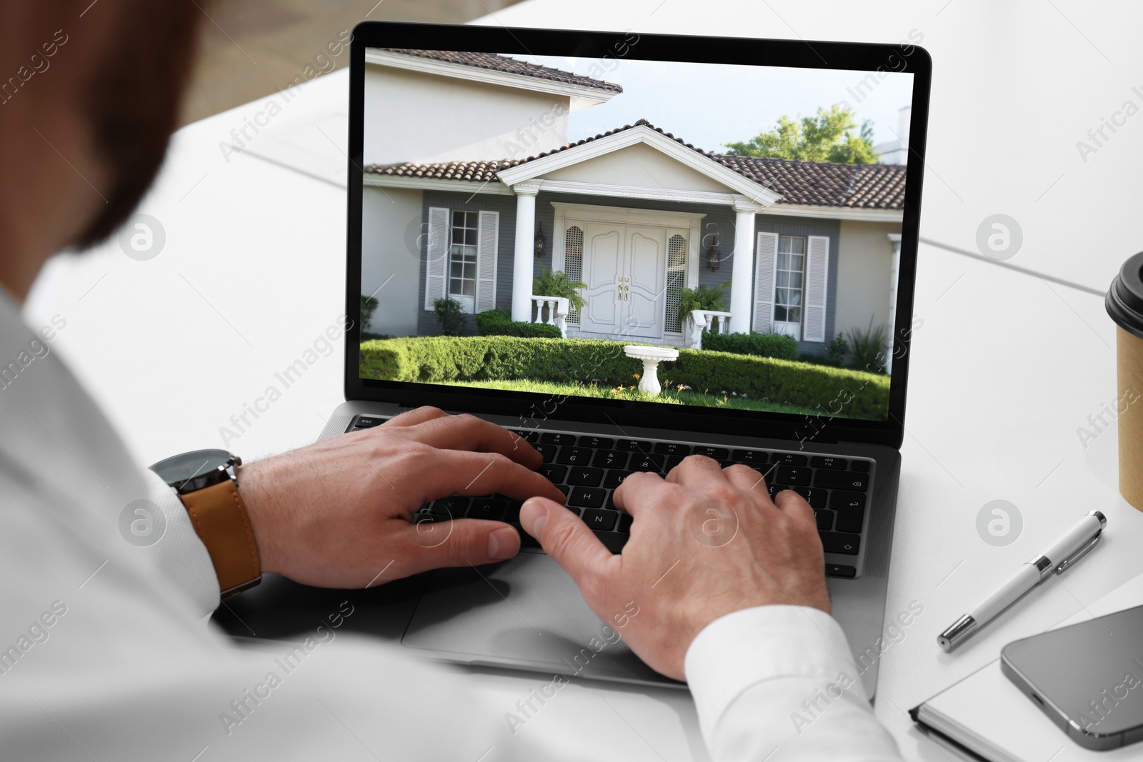 Image of Man looking for house on real estate market website at table, closeup