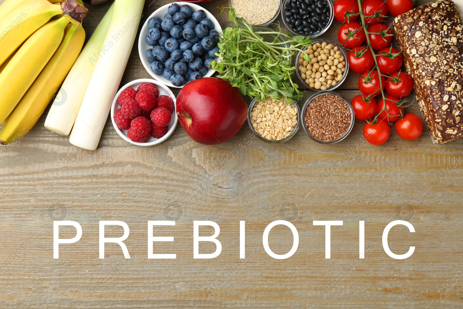 Image of Word Prebiotic and different gut-healthy foods on wooden table, top view