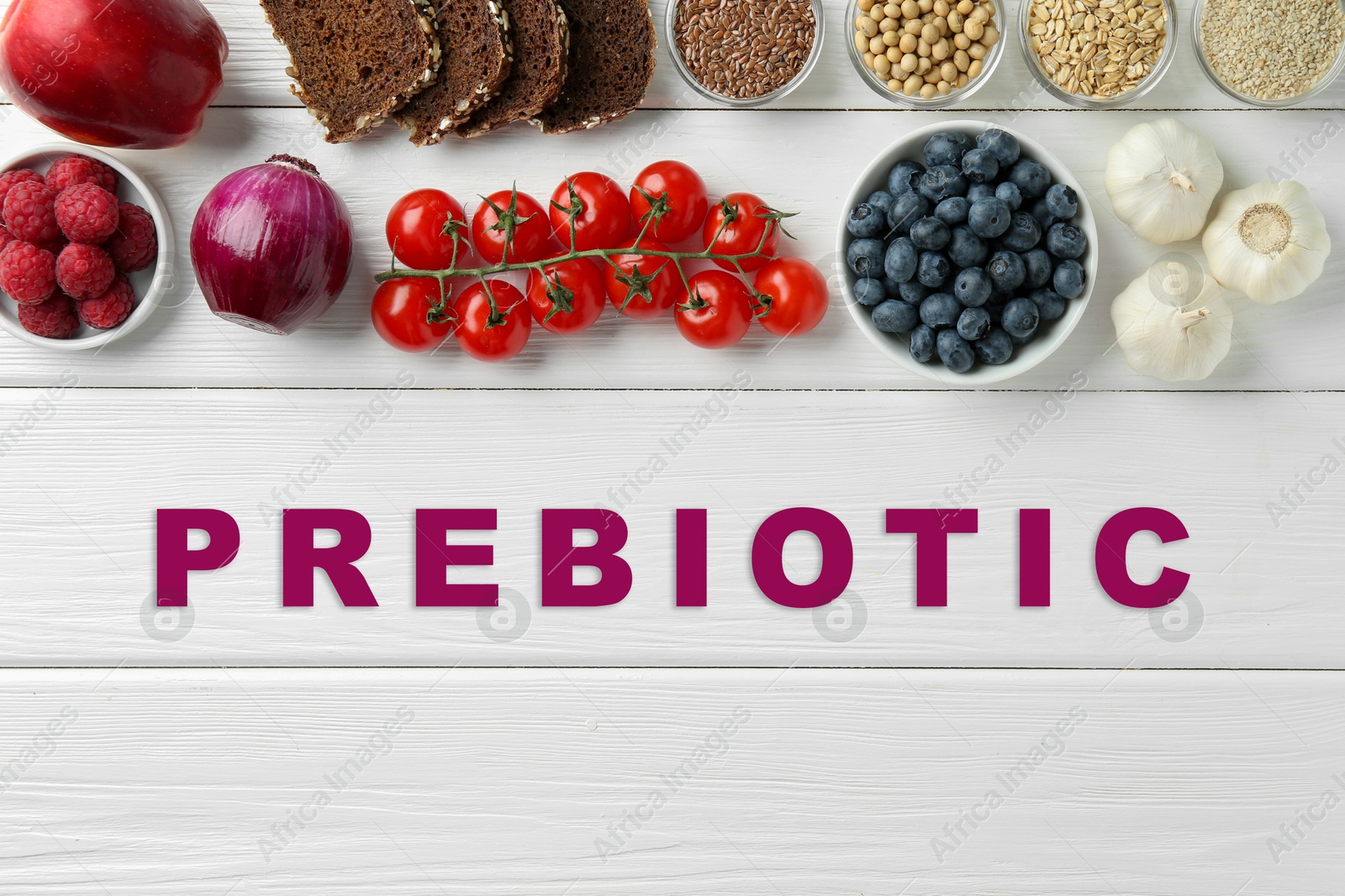 Image of Word Prebiotic and different gut-healthy foods on white wooden table, top view