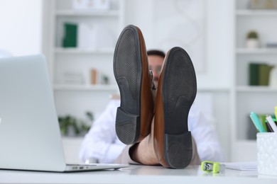 Photo of Businessman holding legs on table in office, selective focus. Break time