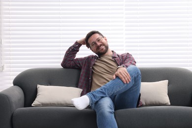 Smiling man relaxing on sofa at home