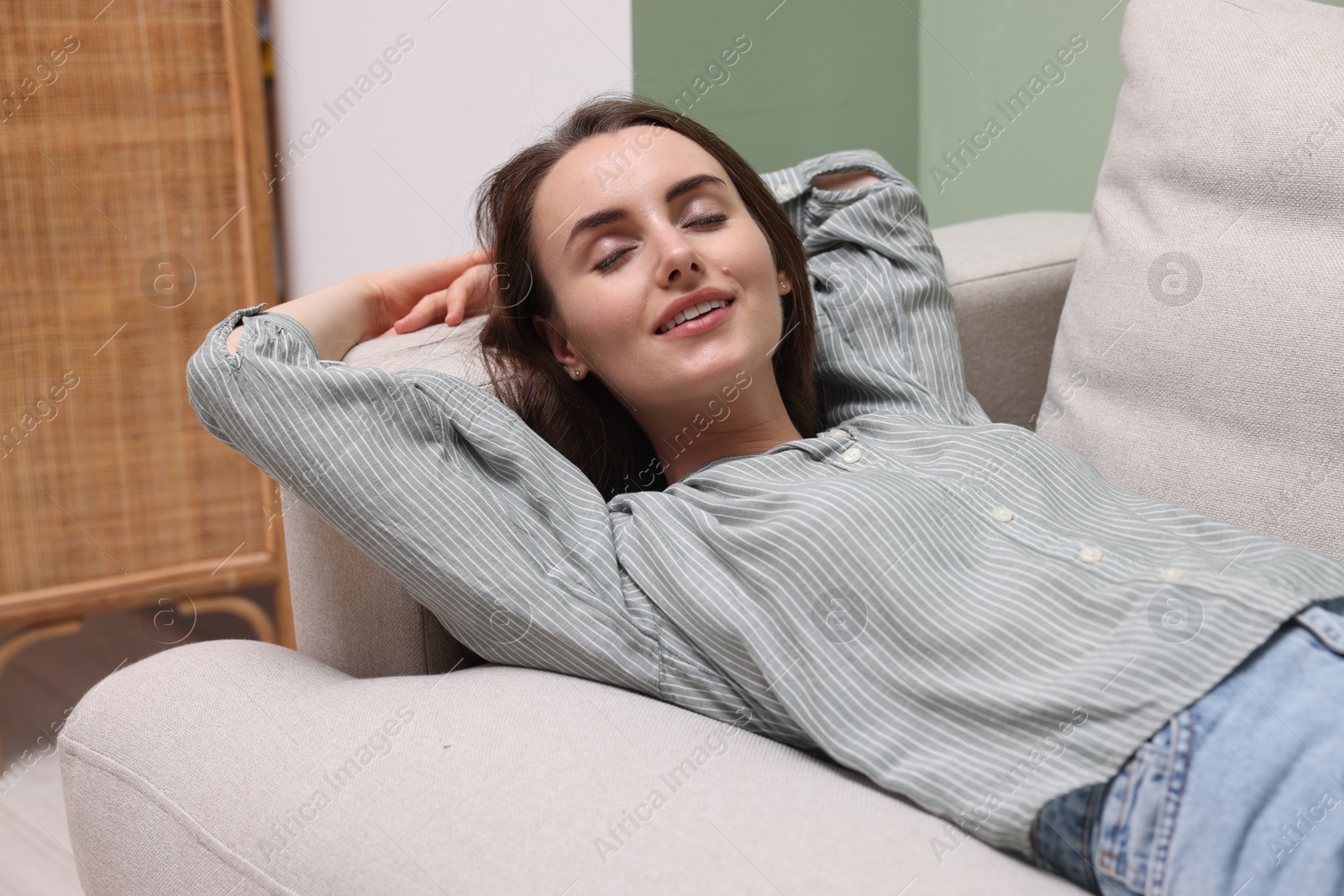 Photo of Smiling woman relaxing on sofa at home