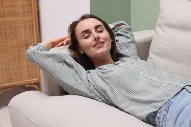 Smiling woman relaxing on sofa at home